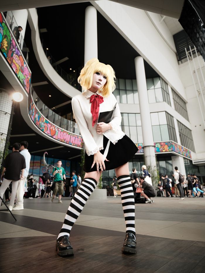 gallery-img-06 Cosplayer in striped outfit poses at a lively urban gathering.