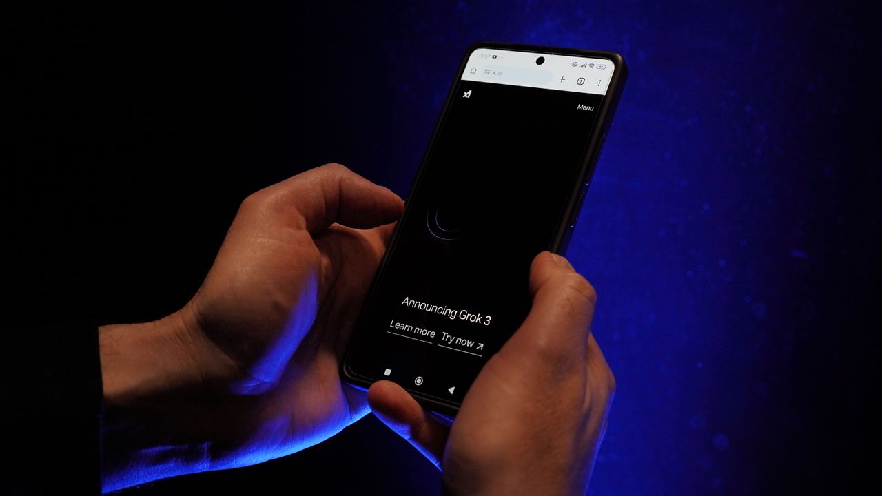 hero-gallery-02 Close-up of hands holding a smartphone displaying 'Announcing Grok 3' on a dark background.