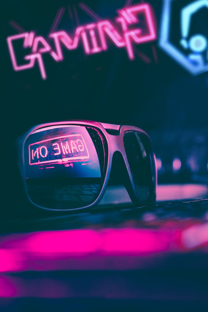 gallery-img-01 Stylish sunglasses placed on keyboard in dark gaming club with colorful neon illumination
